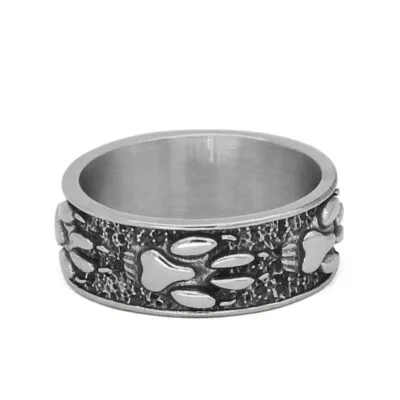 Bague large argentée ornée de pattes de loup en relief sur fond sombre